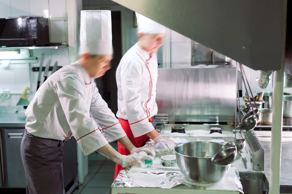 Sanitary day in the restaurant. Repeats wash your workplace. Cooks wash oven, stove and extractor in the Restaurant